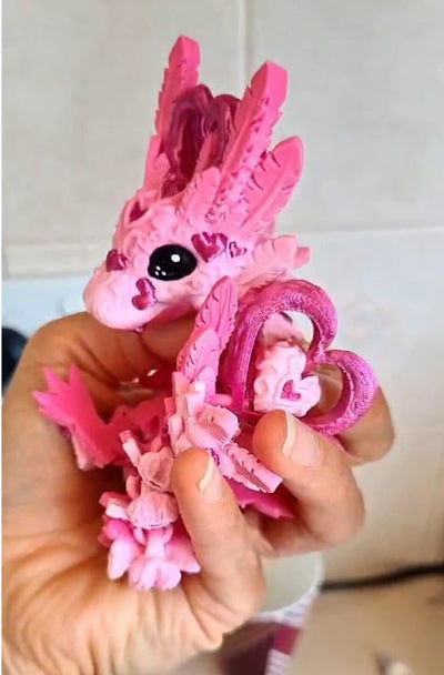Romantic Baby Heart Dragon held in a hand